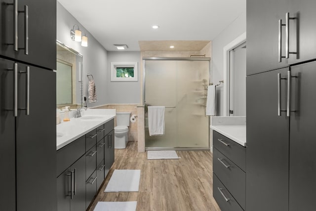 bathroom with toilet, hardwood / wood-style flooring, an enclosed shower, and vanity