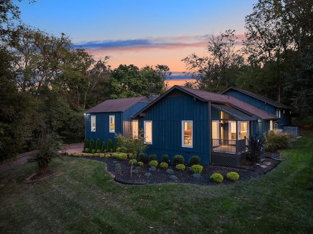 property exterior at dusk featuring a lawn