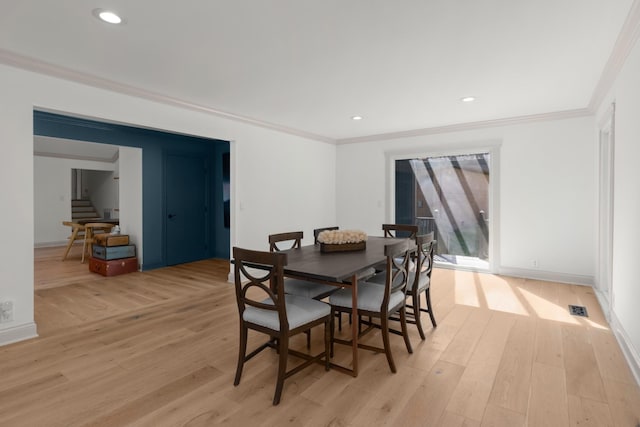 dining room with light hardwood / wood-style floors and crown molding