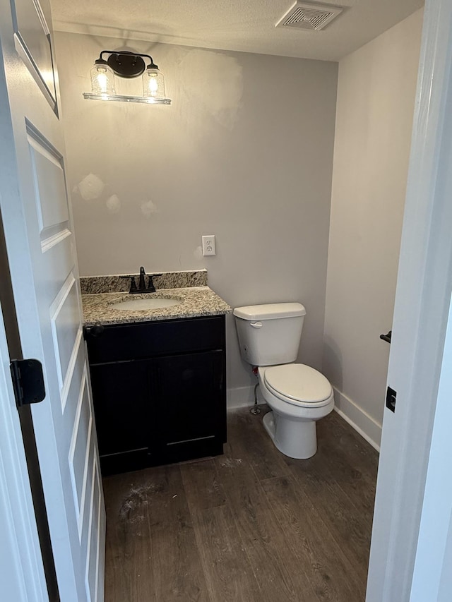 bathroom with toilet, wood-type flooring, and vanity