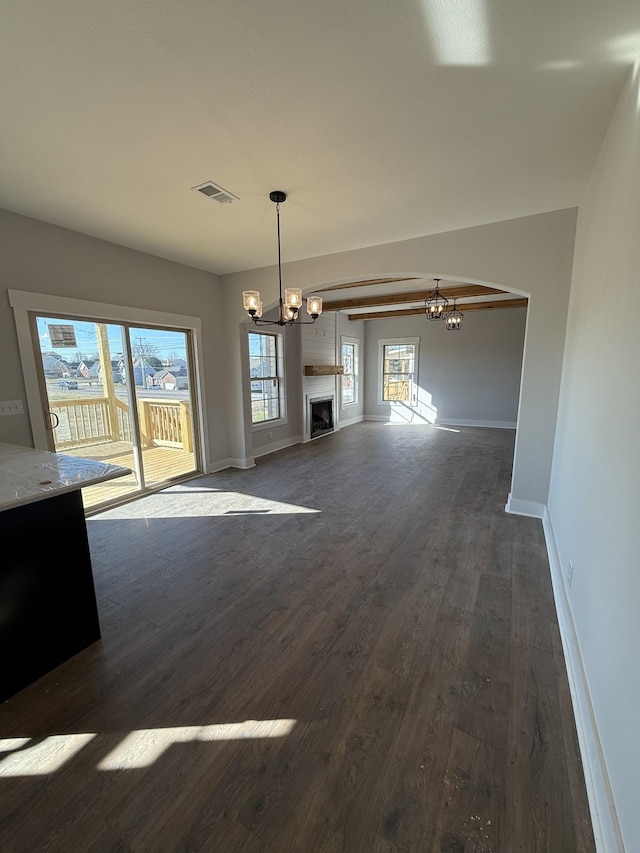 unfurnished living room with dark hardwood / wood-style flooring and an inviting chandelier