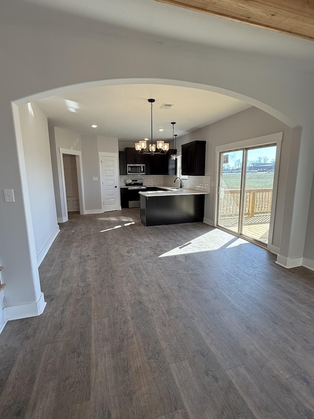 kitchen with a notable chandelier, tasteful backsplash, dark hardwood / wood-style flooring, appliances with stainless steel finishes, and sink