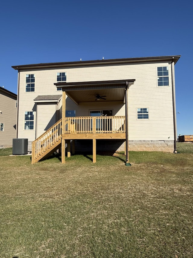 rear view of property with a wooden deck, central air condition unit, and a lawn