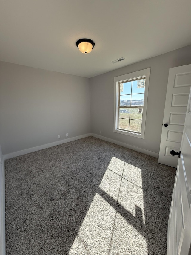 unfurnished room featuring dark carpet