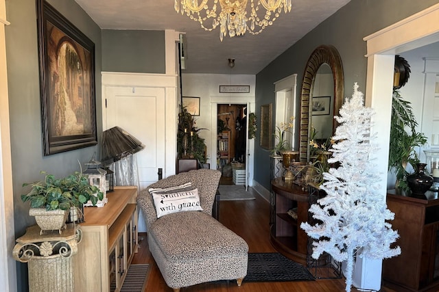 sitting room with a notable chandelier and dark hardwood / wood-style floors