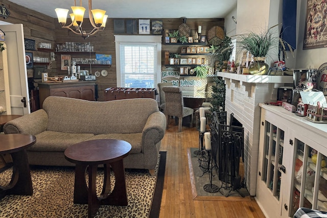 living room featuring an inviting chandelier, wood walls, and hardwood / wood-style floors