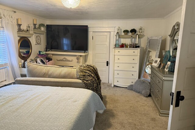 bedroom featuring a textured ceiling, crown molding, and light carpet