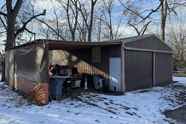 snow covered structure featuring a garage