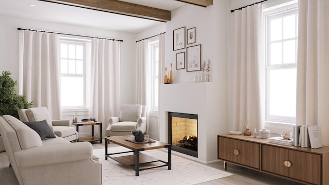 living area with beamed ceiling, light hardwood / wood-style flooring, and a healthy amount of sunlight