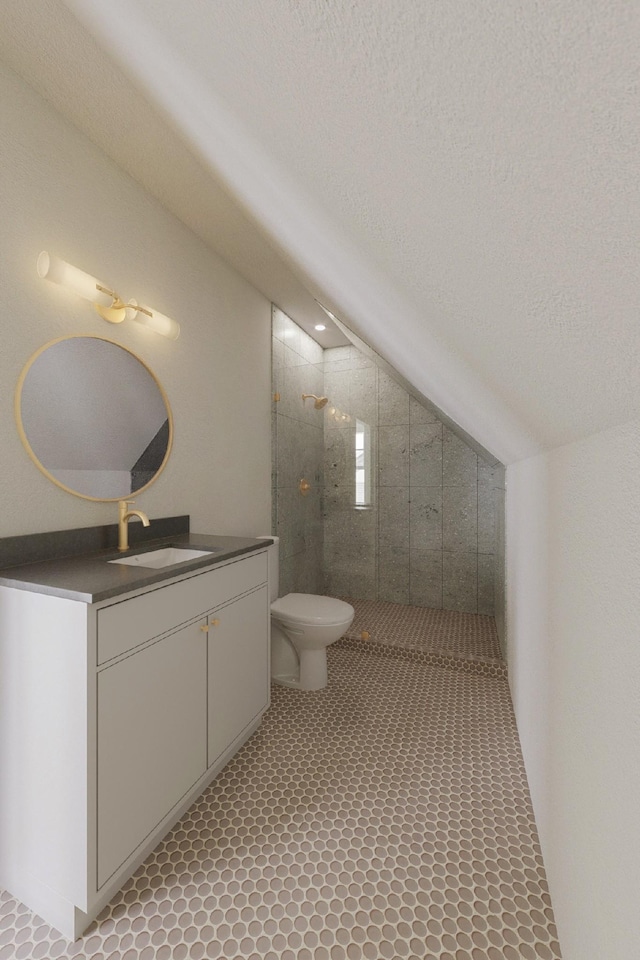 bathroom with toilet, a textured ceiling, vaulted ceiling, a tile shower, and vanity