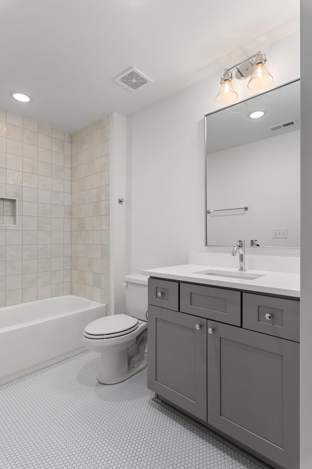 full bathroom with toilet, vanity, tile patterned floors, and tiled shower / bath combo