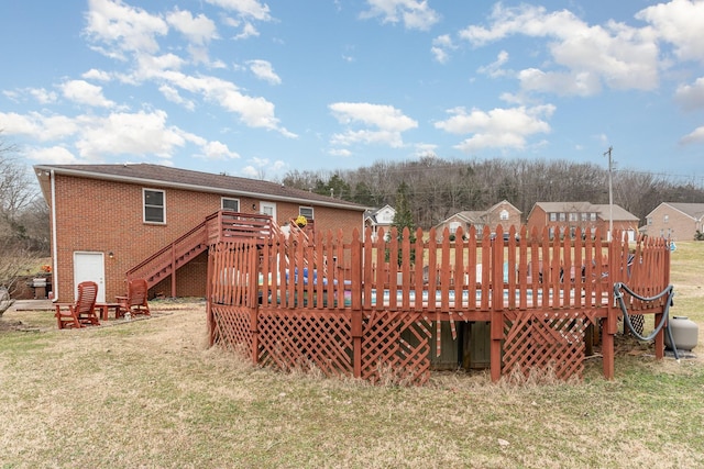 rear view of property with a yard and a wooden deck