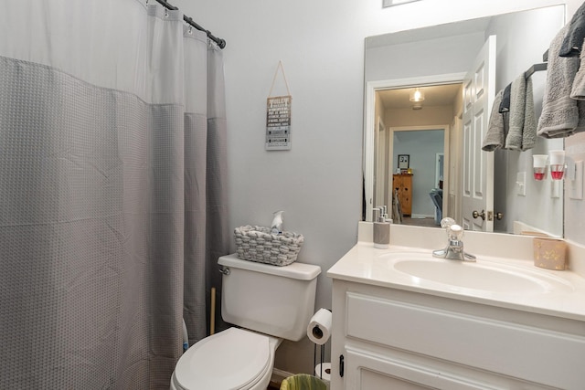 bathroom featuring toilet, a shower with shower curtain, and vanity