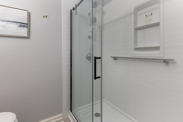 bathroom with an enclosed shower and toilet