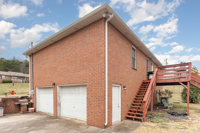 view of side of home featuring a garage and a wooden deck