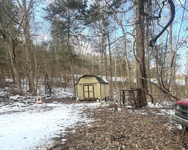 yard layered in snow featuring a shed