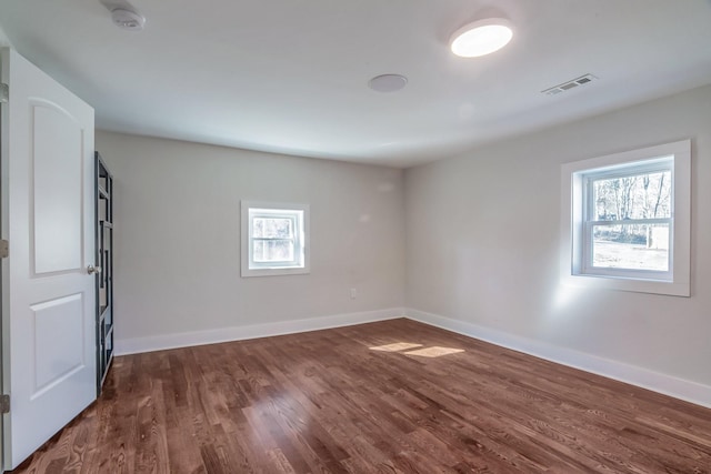 unfurnished room with dark hardwood / wood-style flooring