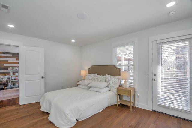 bedroom featuring wood-type flooring and access to exterior