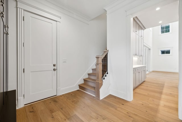 entryway featuring ornamental molding and light hardwood / wood-style floors