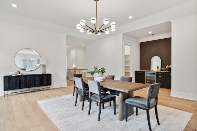 dining space featuring light hardwood / wood-style floors, beverage cooler, and a chandelier