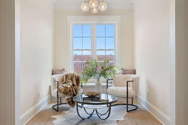 sitting room with crown molding and light hardwood / wood-style flooring