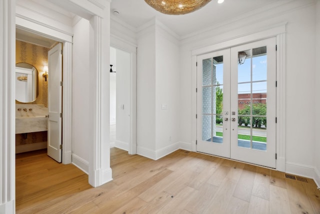 doorway featuring crown molding, french doors, and light hardwood / wood-style flooring