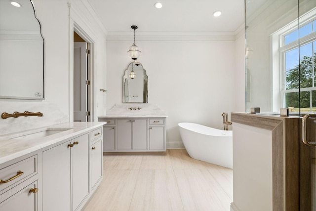 bathroom with ornamental molding, a washtub, and vanity