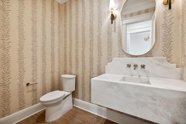 bathroom featuring toilet, hardwood / wood-style flooring, and crown molding