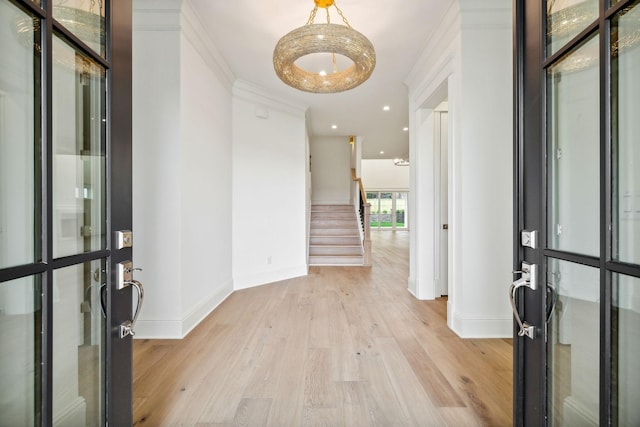 entrance foyer with ornamental molding and light wood-type flooring