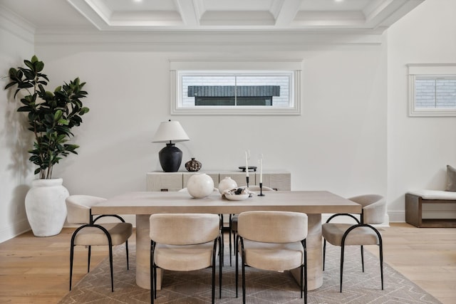 dining area featuring coffered ceiling, light hardwood / wood-style floors, crown molding, and beam ceiling