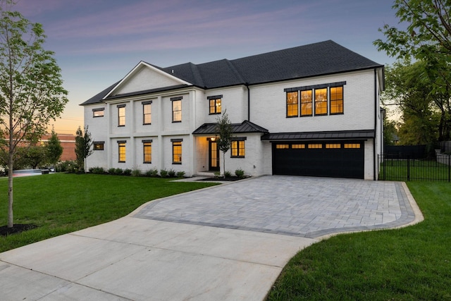 view of front of house featuring a garage and a yard