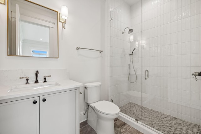 bathroom featuring an enclosed shower, vanity, and toilet