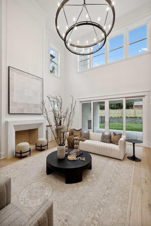 living room featuring a towering ceiling, french doors, hardwood / wood-style floors, and a chandelier