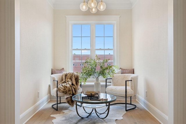 sitting room with light wood-type flooring and crown molding