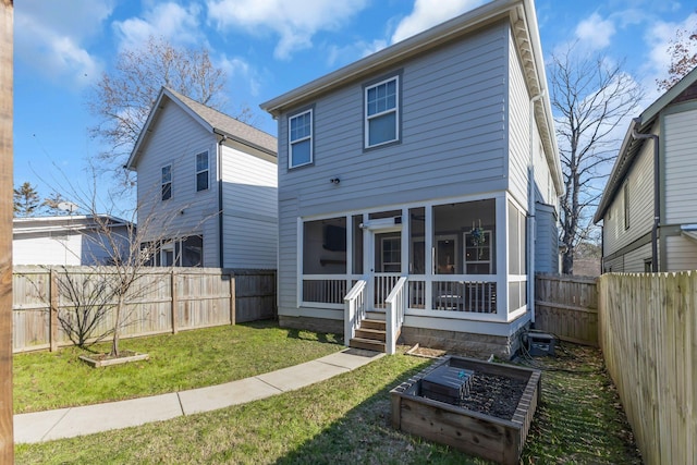 rear view of house with a yard and a sunroom