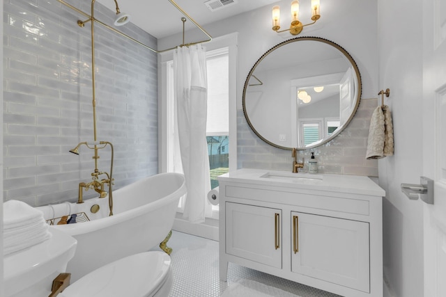 bathroom with toilet, tile walls, backsplash, tile patterned floors, and vanity