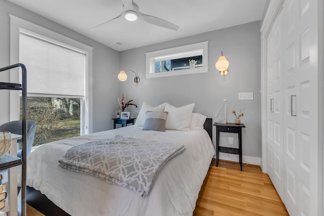 bedroom with ceiling fan, light wood-type flooring, and a closet