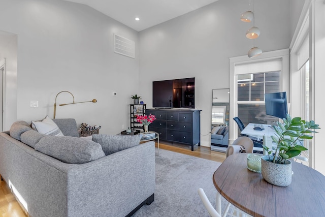 living room with lofted ceiling and light hardwood / wood-style flooring