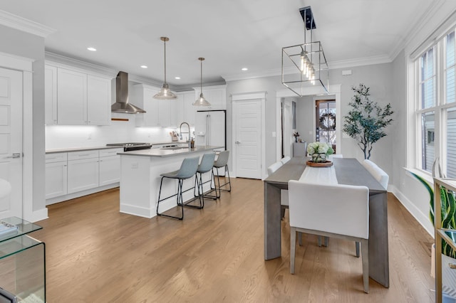 dining space with sink, light hardwood / wood-style flooring, and crown molding