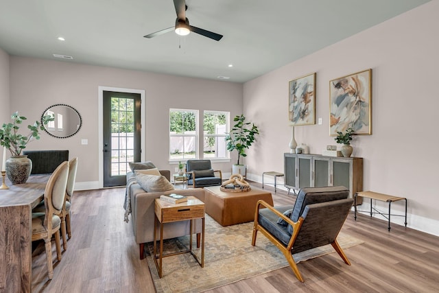 living room featuring ceiling fan and light hardwood / wood-style floors