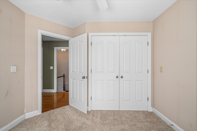 unfurnished bedroom featuring carpet flooring, a closet, and ceiling fan