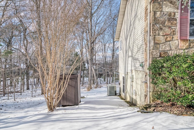 yard covered in snow with central air condition unit