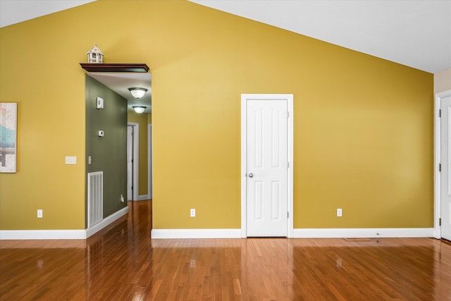 unfurnished bedroom with lofted ceiling and hardwood / wood-style floors