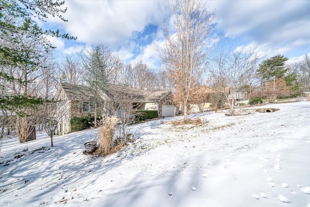 yard covered in snow featuring a garage