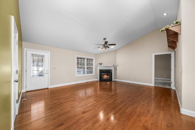 unfurnished living room with ceiling fan, hardwood / wood-style floors, lofted ceiling, and a fireplace