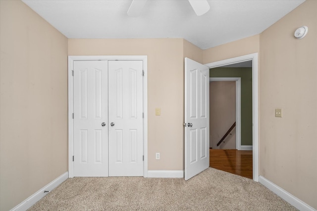 unfurnished bedroom featuring a closet, ceiling fan, and carpet