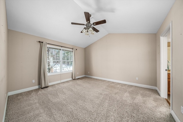 carpeted spare room with ceiling fan and vaulted ceiling