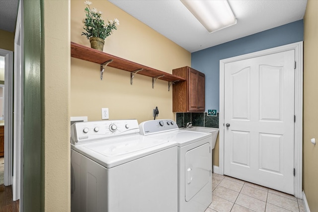 laundry room with light tile patterned floors, cabinets, and separate washer and dryer