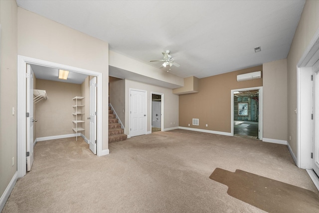 interior space featuring ceiling fan, a wall mounted AC, and light carpet