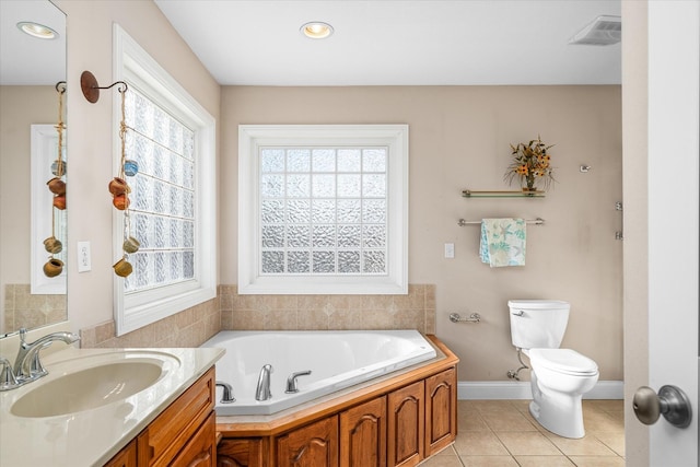 bathroom featuring a tub to relax in, tile patterned flooring, toilet, vanity, and a wealth of natural light